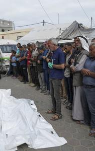 Mourners pray over the body of Palestinians who were killed in an Israeli airstrike in Gaza strip, at the Al Aqsa hospital in Deir Al Balah, Gaza
